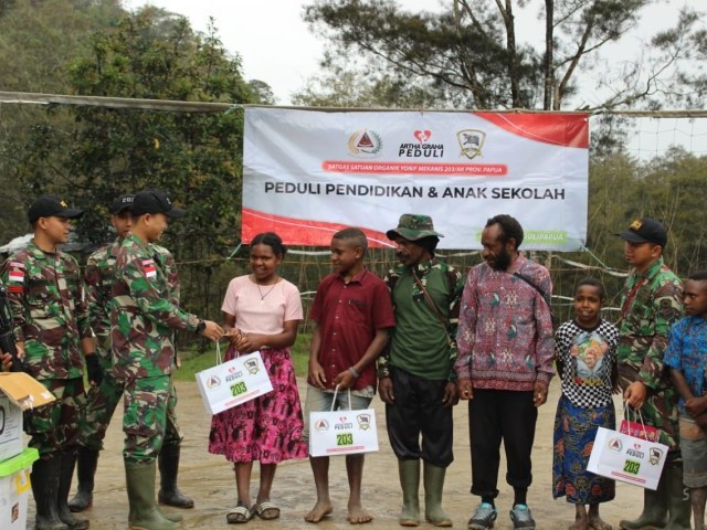 Satgas Yonif Mekanis 203/AK Bekerja Sama dengan Artha Graha membagikan perlengkapan Sekolah untuk Anak-anak Pegunungan Tengah