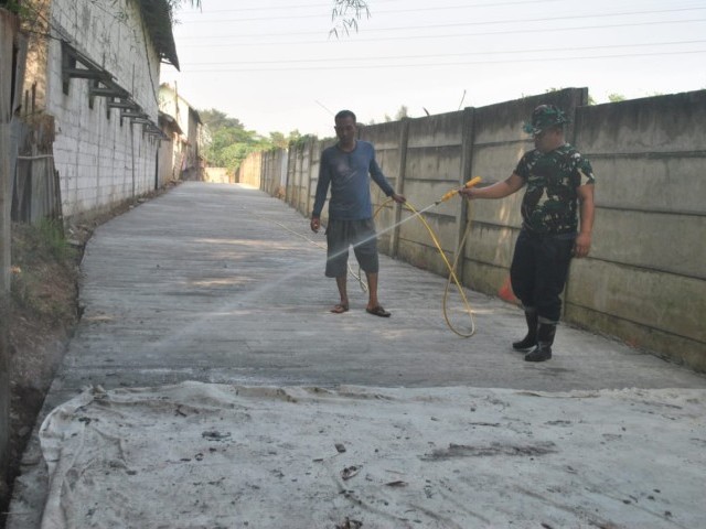 Pertahankan Kualitas Cor Jalan, Satgas TMMD Lakukan Penyiraman