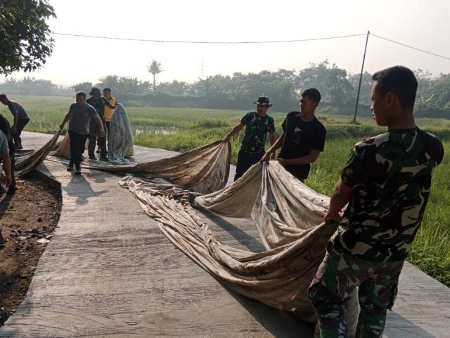 Gigih Dan Semangat, Satgas TMMD Kodim 0510/Tigaraksa Buka Plastik Penutup Jalan Beton