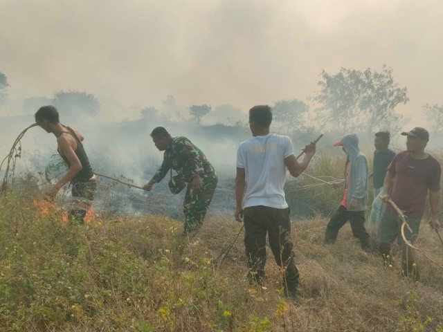 Babinsa Koramil 11/Pasar Kemis Padamkan Kebakaran lahan Kosong