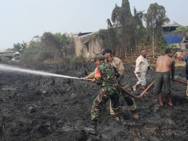 Kerjasama TNI-Polri dan Damkar, Babinsa Sertu Kusnanto dan Tim Berhasil Padamkan Api Yang Membakar Lahan Kosong