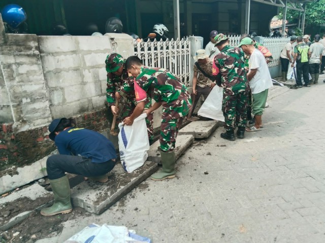 Anggota Koramil 06/CBD Pembersihan Saluran Air Yang Mampet