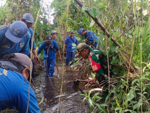 Menjaga Kebersihan Lingkungan, Babinsa Bintaro Serma Armawan Bersama 3 Pilar Kerja Bakti Bersihkan Saluran Air