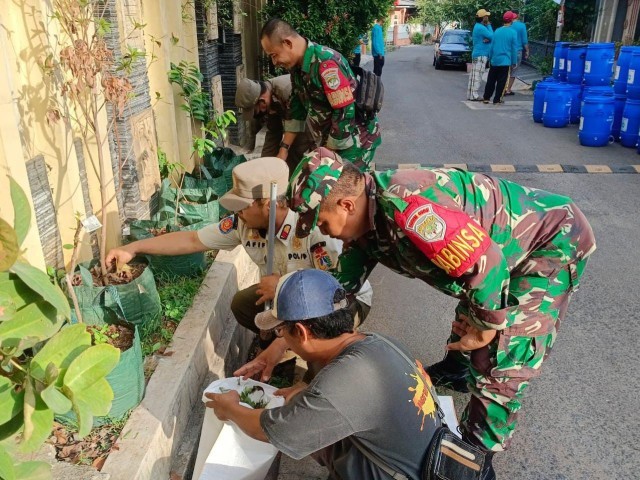 Pembersihan Selokan Air dan Pemberian Pupuk APK oleh Babinsa Koramil Duren Sawit