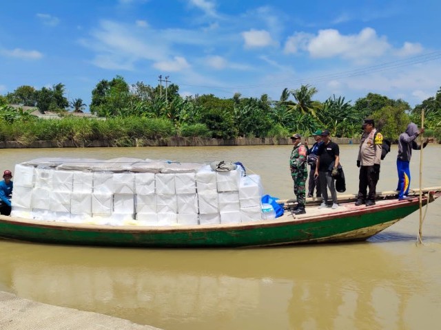Gunakan Perahu Kayu, Babinsa Kawal Pendistribusian Kotak Suara