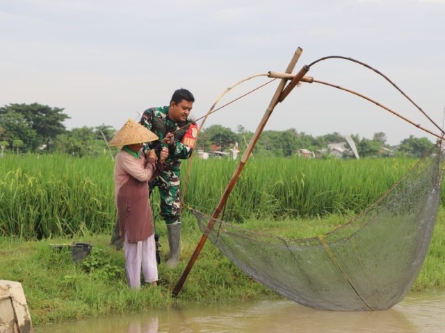 Satgas TMMD Ke-119 Sempatkan Waktu Bantu Masyarakat mencari ikan ditengah kesibukan pembangunan