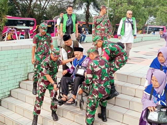Anggota Kodim 0510/Trs Bantu Jemaah Haji Naik Bus Pemberangkatan