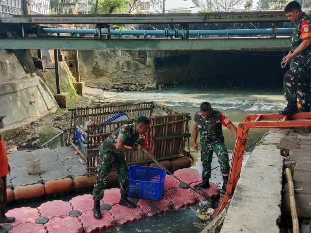Babinsa Koramil 02/Matraman dan Petugas UPS Bersihkan Sampah di Sepanjang Kali
