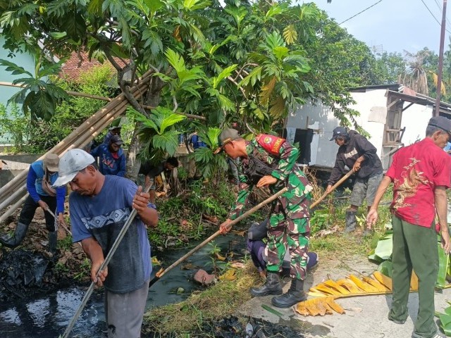 Babinsa Koramil 10/Sukatani Ajak Aparatur Desa Sukajadi Gelar Kerja Bakti Antisipasi DBD