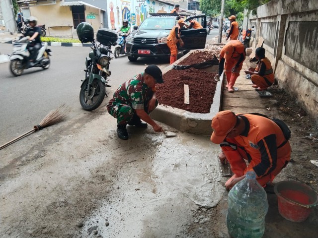 Babinsa Koramil 05/KJ Giat Perapian Trotoar Jalan, Pembersihan Sampah dan Rumput Liar