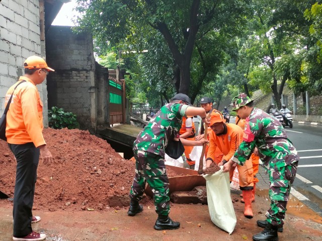 Karya Bhakti Koramil Cipayung Bersama PPSU Bersihkan Saluran Air