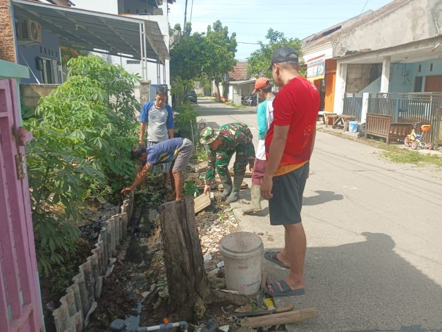 Babinsa Koramil Setu Gotong Royong Bersihkan Saluran Air