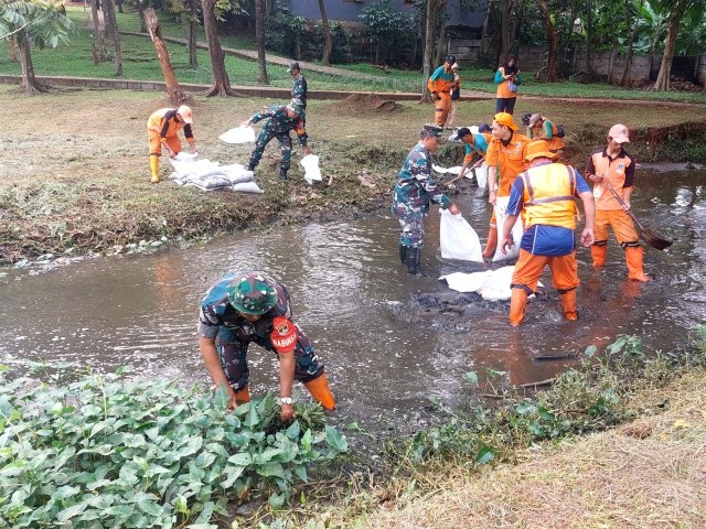 Babinsa Koramil Cipayung Bersinergi Bersihkan Kali Taman Bambu