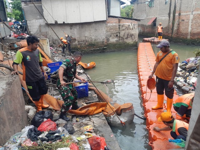 Membersihkan Sampah di Sungai Pintu Air Kapuk Tanggul Barat